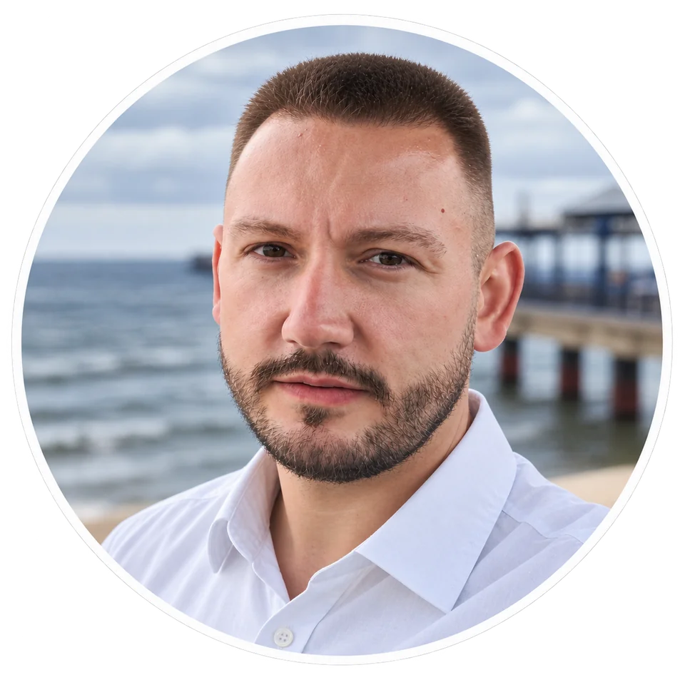 Photo of Adrian Jakubiak by the sea, wearing a white shirt